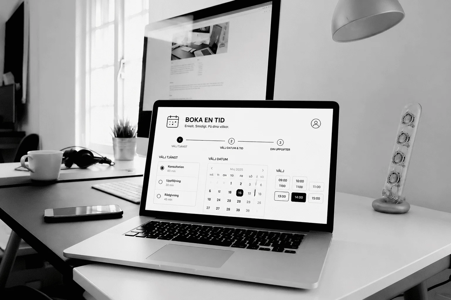 Bärbar dator visar digital tidsbokning på skrivbord