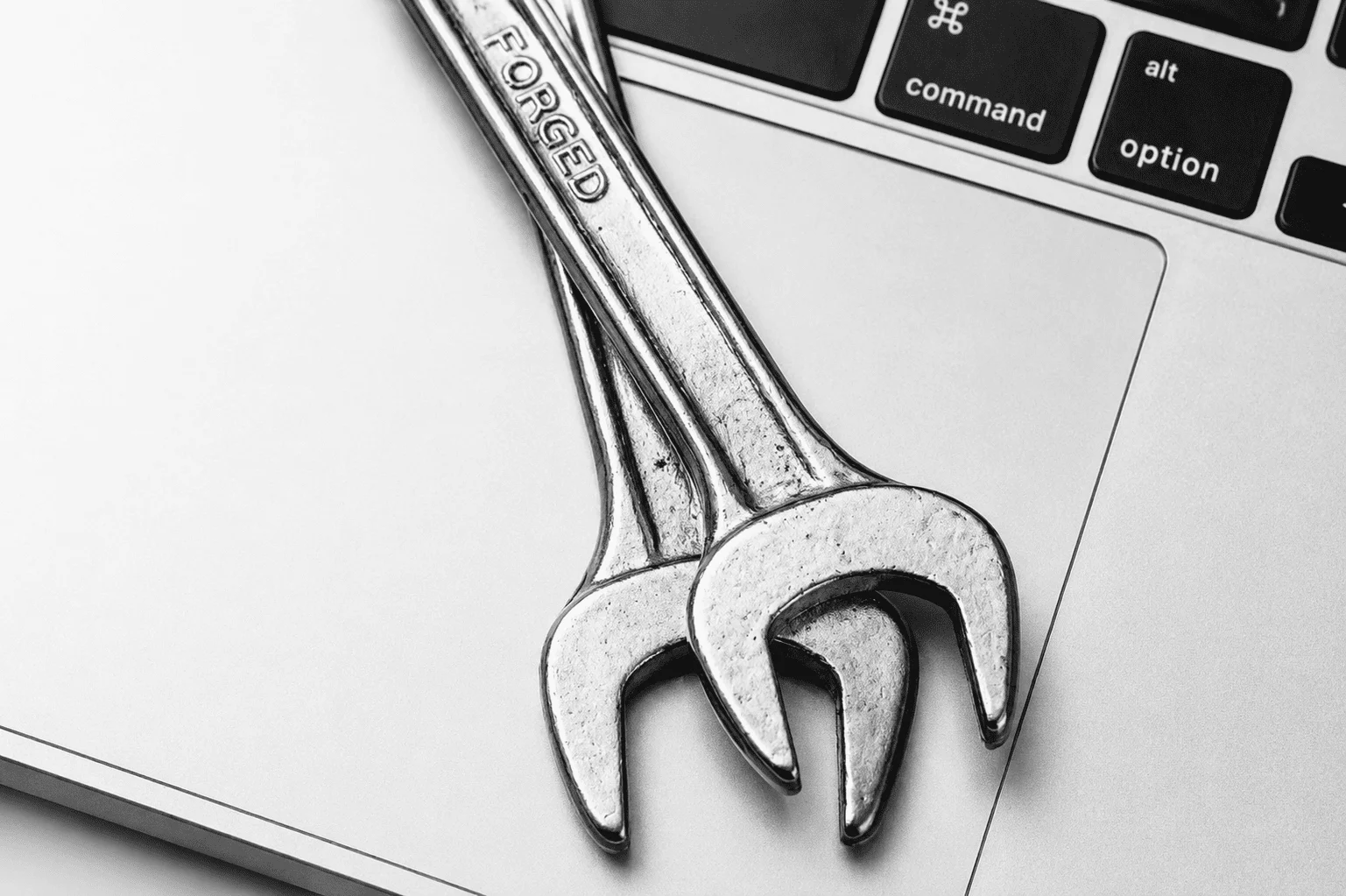 Two spanners resting on a laptop keyboard